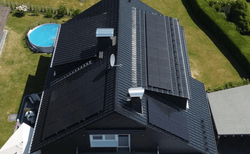 Solarmodule auf dem Dach eines Hauses, bewölkter Himmel im Hintergrund