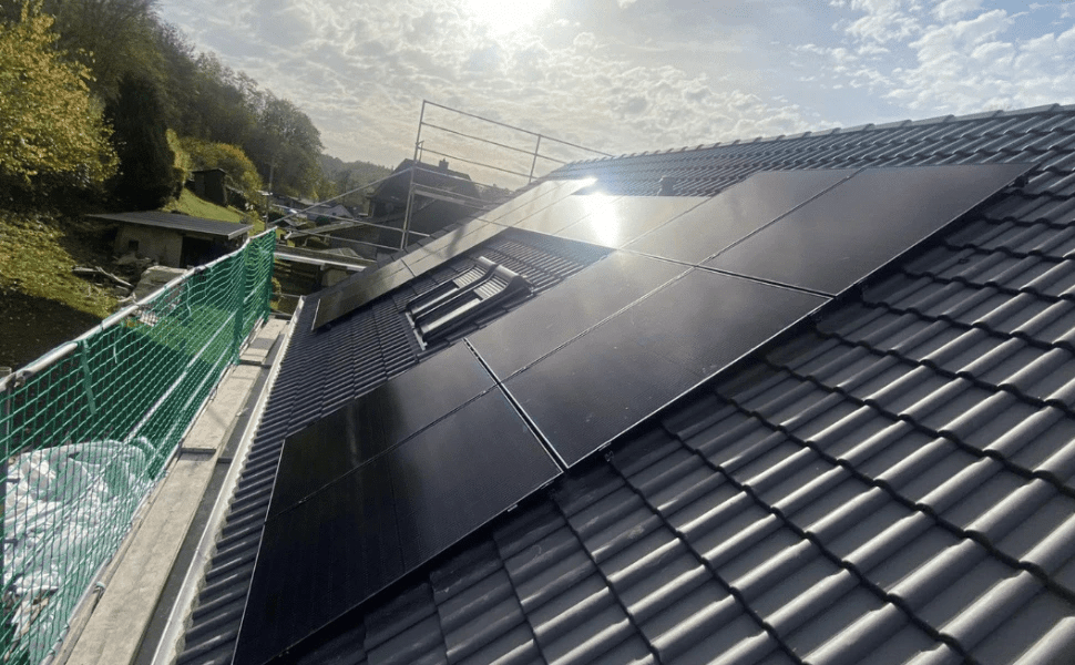 Installierte Solarmodule auf einem Hausdach mit Baugerüst und Sicherheitsnetzen
